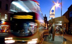 view of an installed bus shelter with a blurred bus leaving the bus stop.