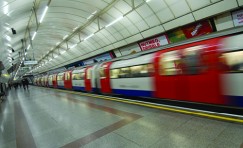 view of a train whizzing past in an underground station.
