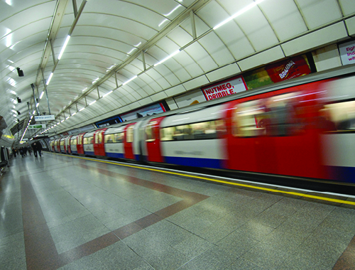 view of a train whizzing past in an underground station.