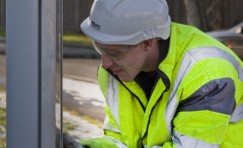 view of Trueform employee performing maintenace on bus shelter.
