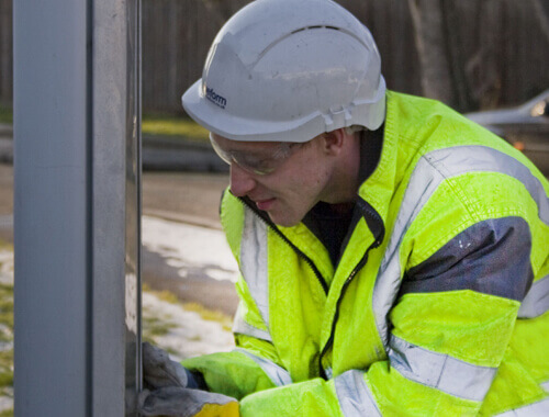 view of Trueform employee performing maintenace on bus shelter.
