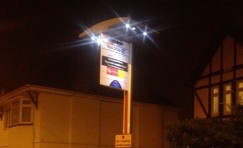 view of an installed elite solar bus stop sign at night.