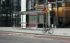 view of a Landmark London bus shelter and bus stop sign.