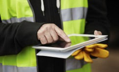 view of Trueform employee in a hi-vis jacket using a tablet.