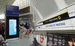 Passengers navigating a modern rail station using clear wayfinding signage, digital passenger information displays and directional signs designed to improve accessibility and passenger flow.